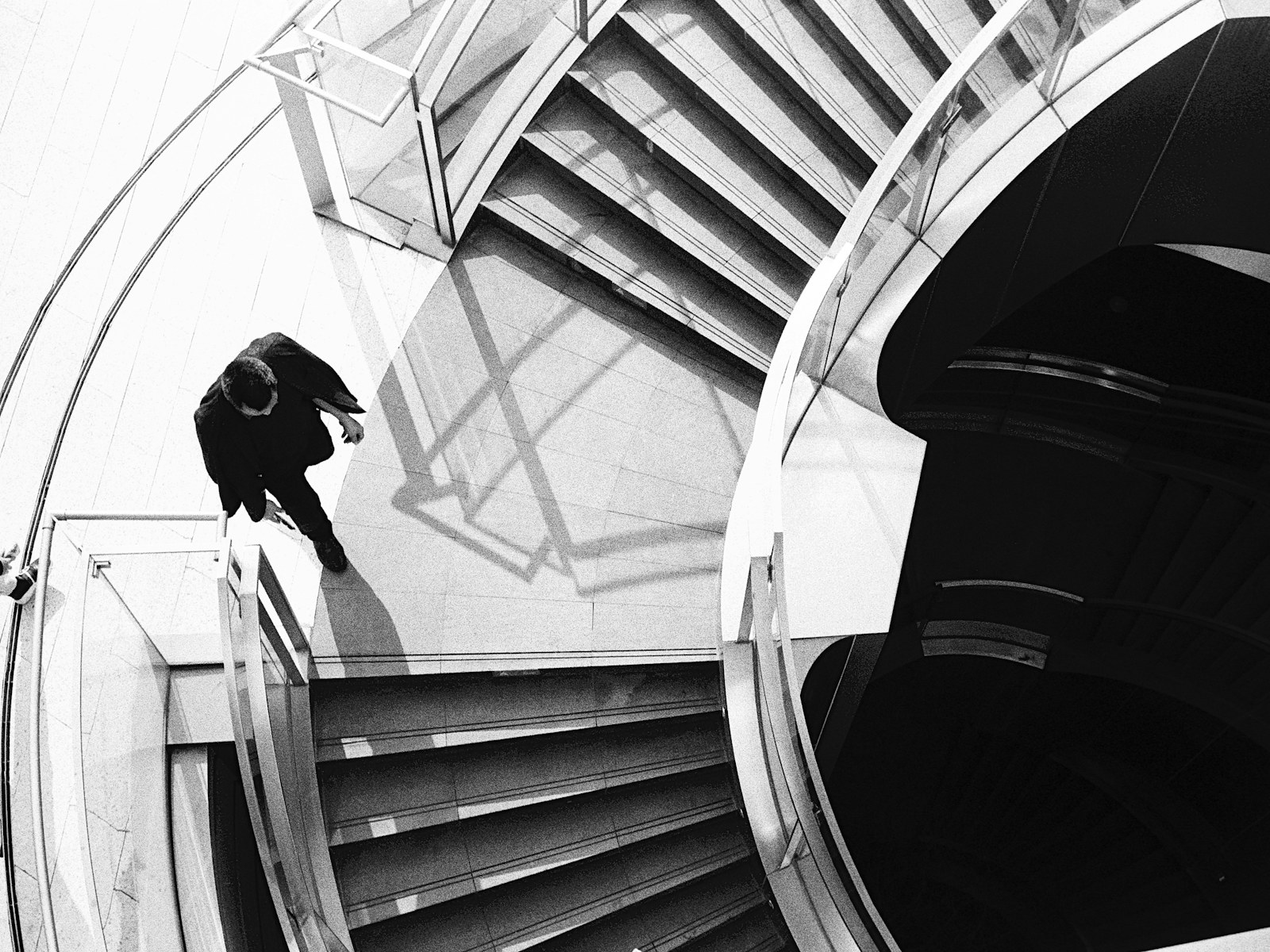 A man walks down modern spiral stairs