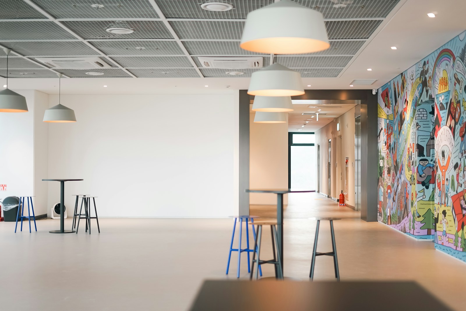 a room with a lot of stools and a mural on the wall