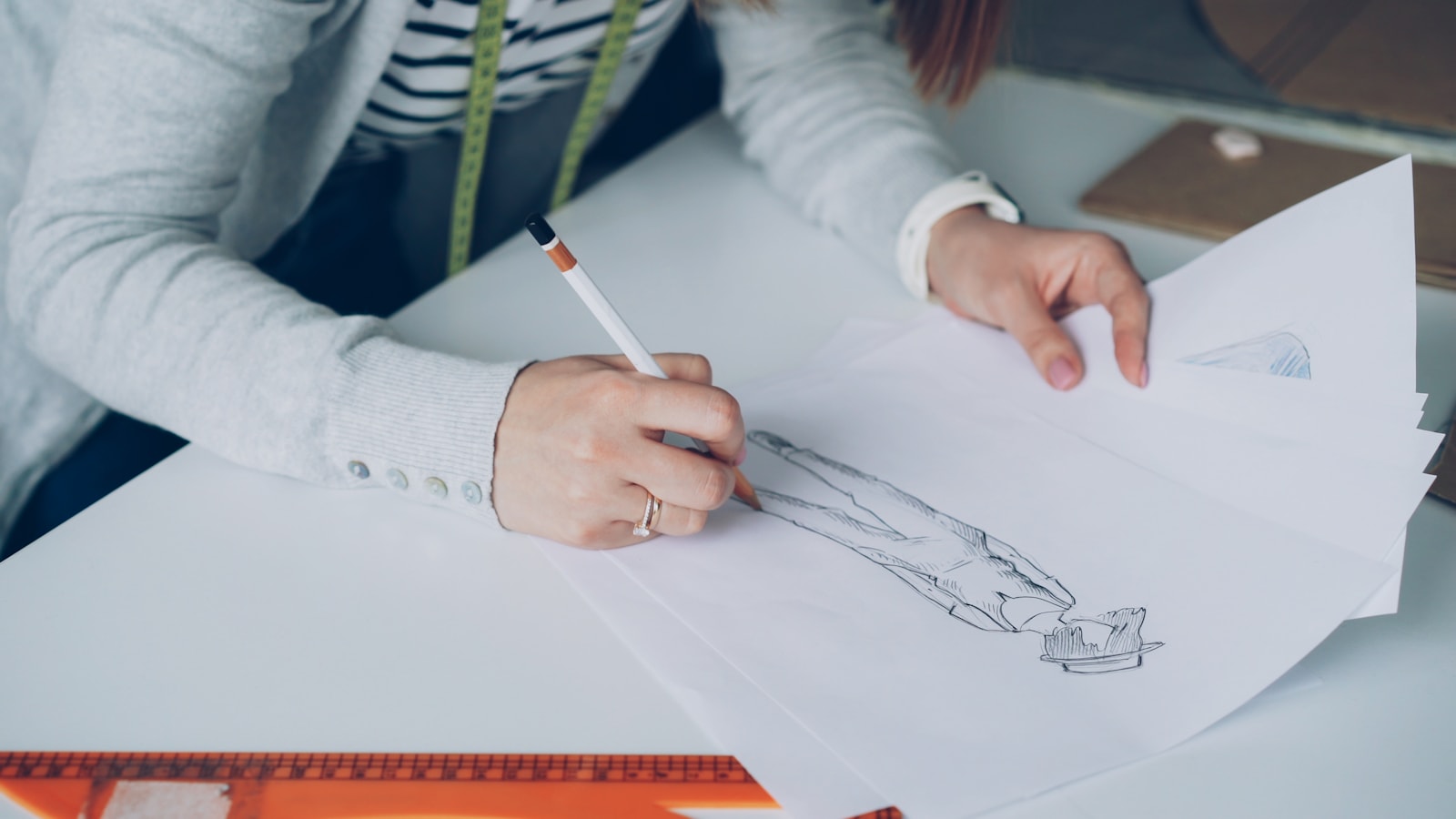 A fashion designer sketches a garment