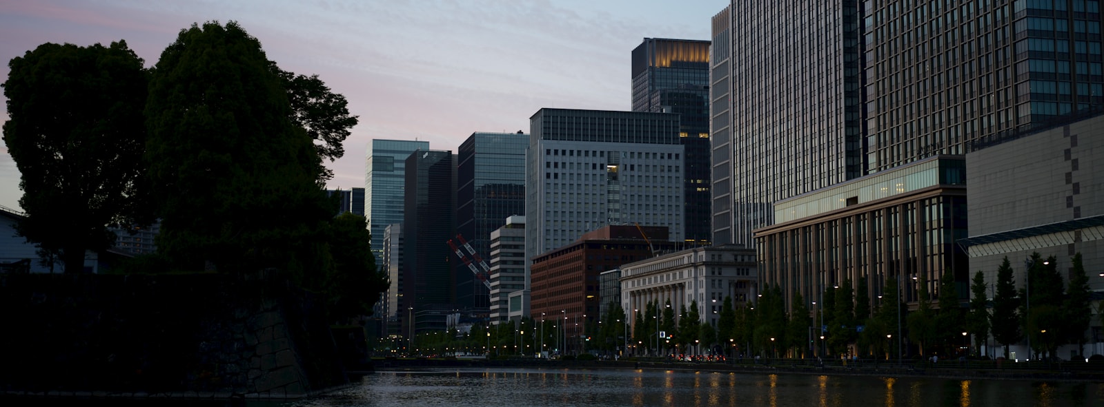 Modern city buildings reflected in water at twilight