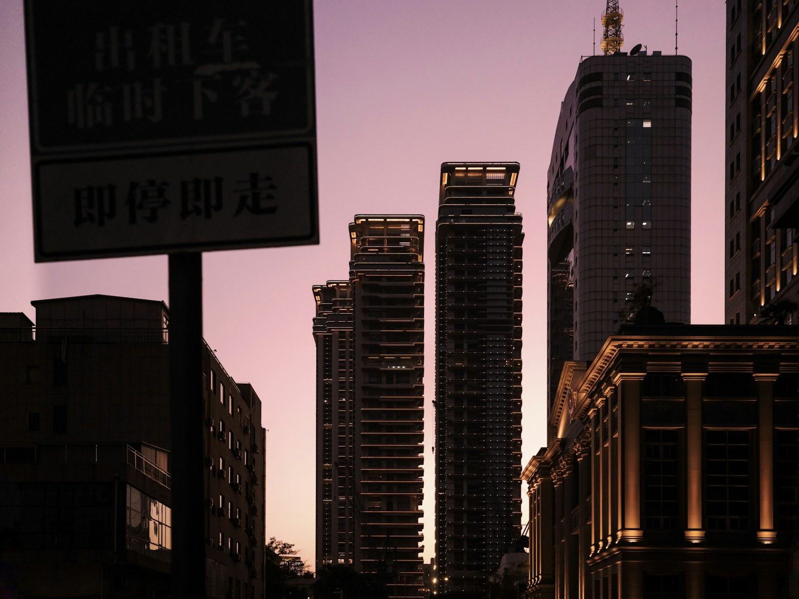 Skyscrapers silhouetted against a purple sunset sky