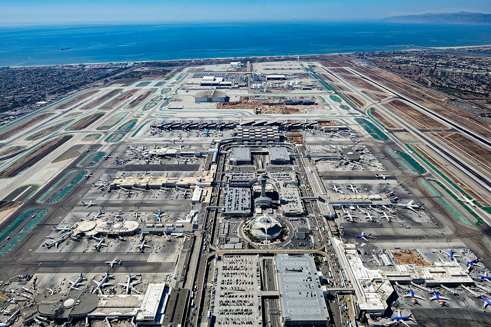 Aerial view of a large airport with ocean in background
