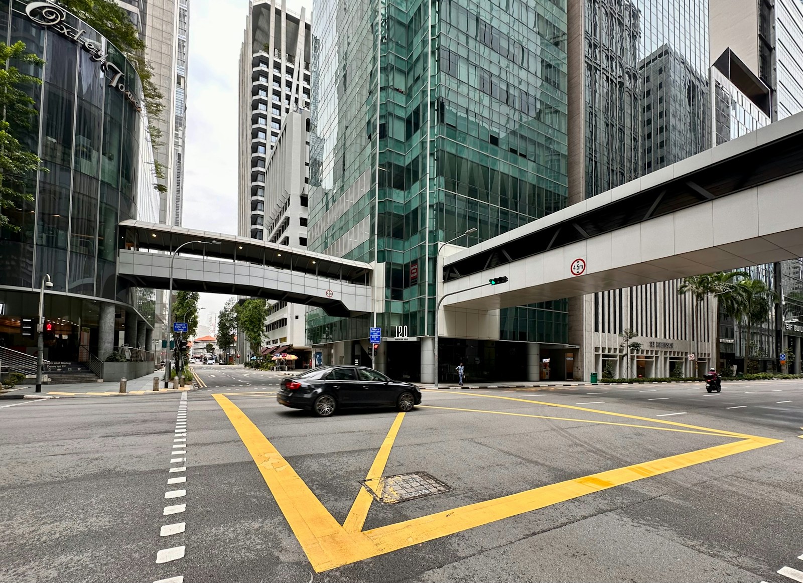 a black car driving down a street next to tall buildings