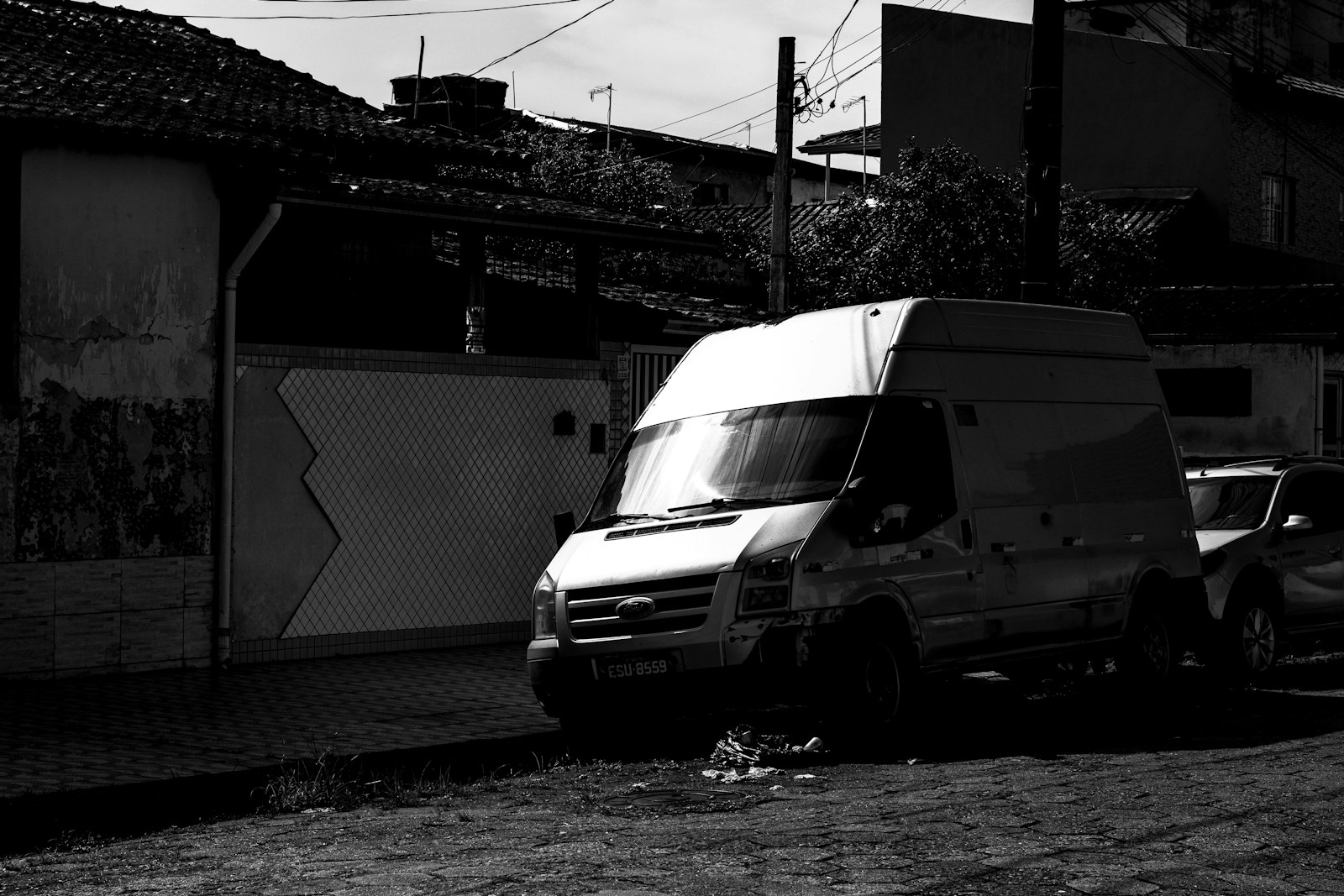 White van parked on a street next to buildings
