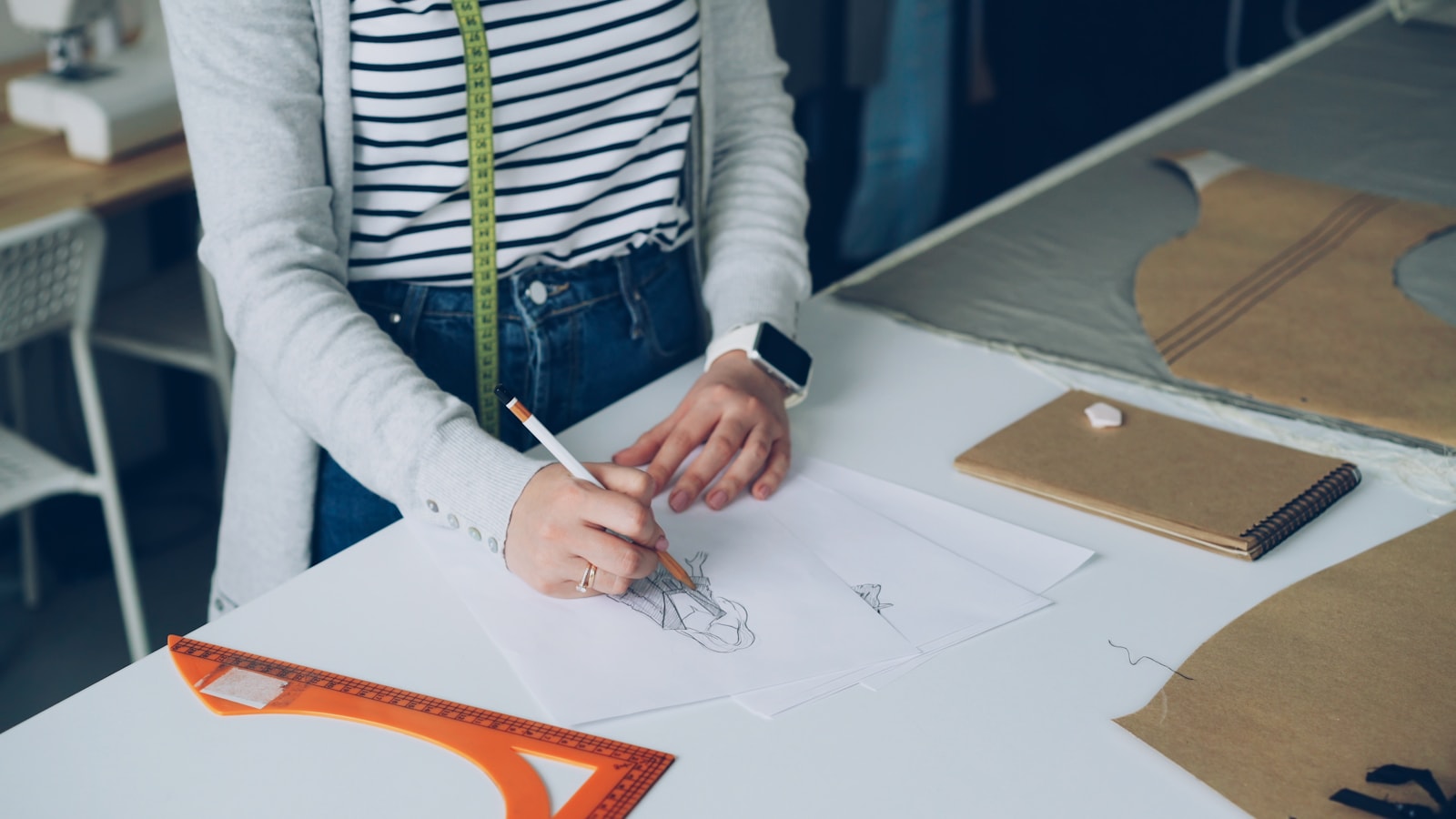 A fashion designer is sketching designs on paper