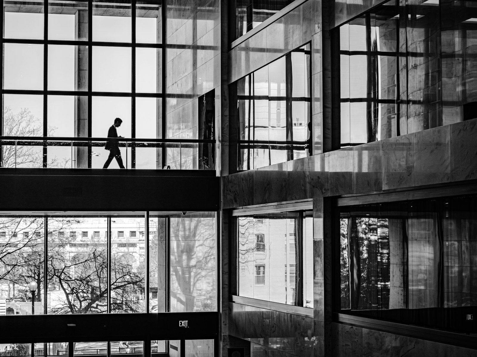 A person walks on a walkway inside a modern building