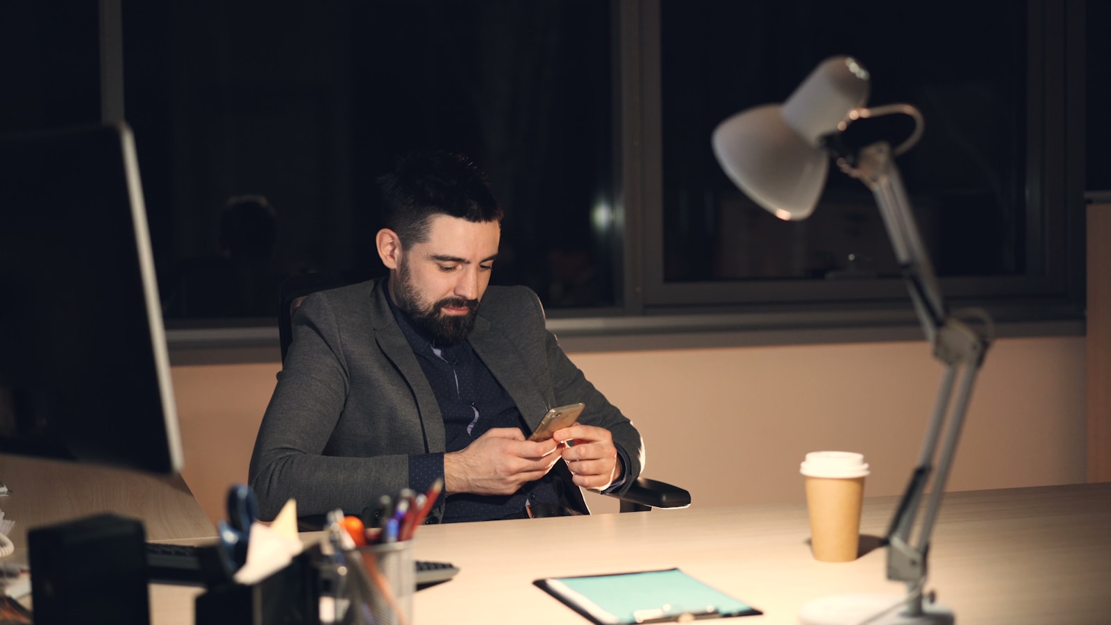 Man working late on his phone at desk