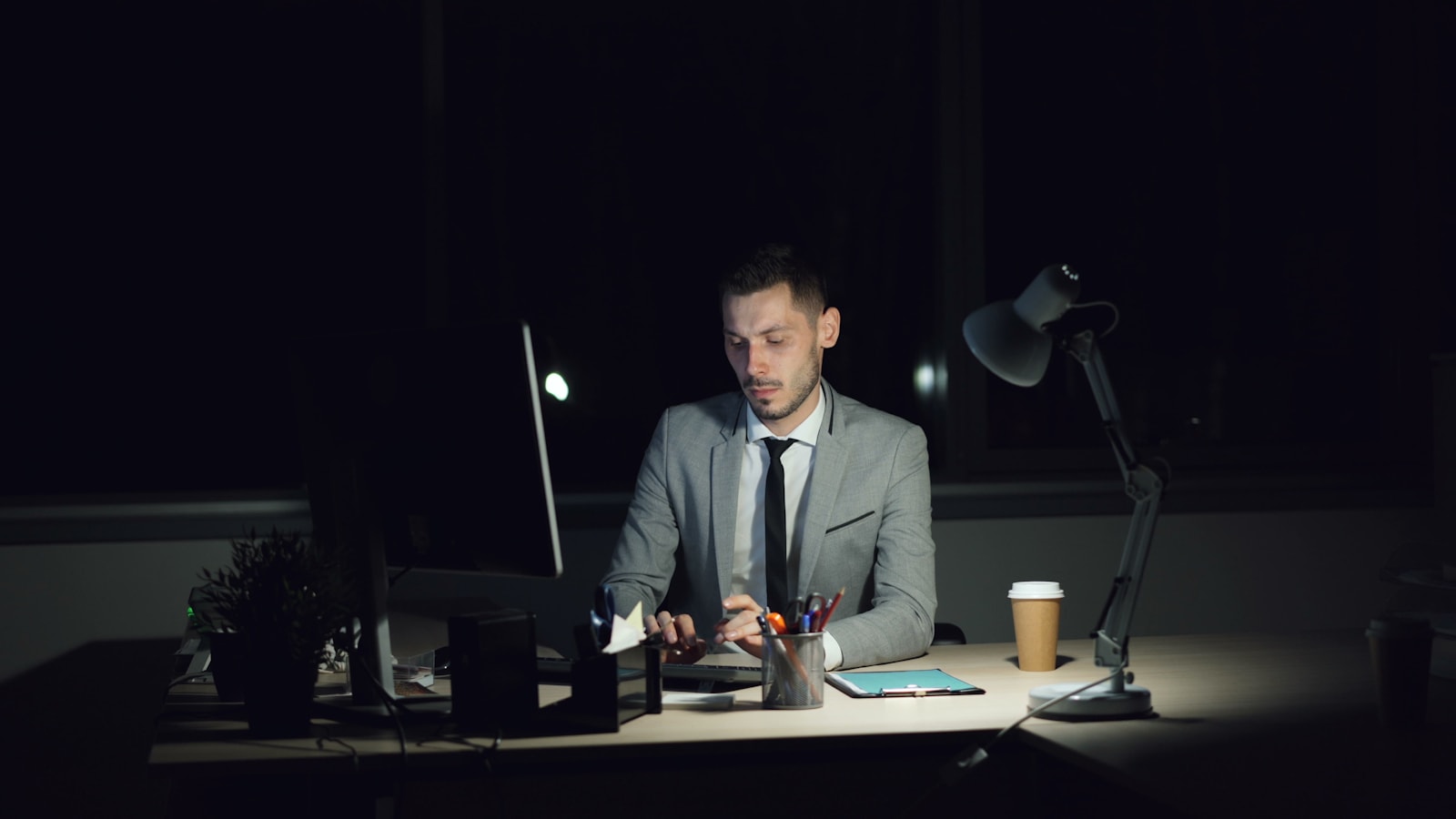 Man working late at his desk with coffee