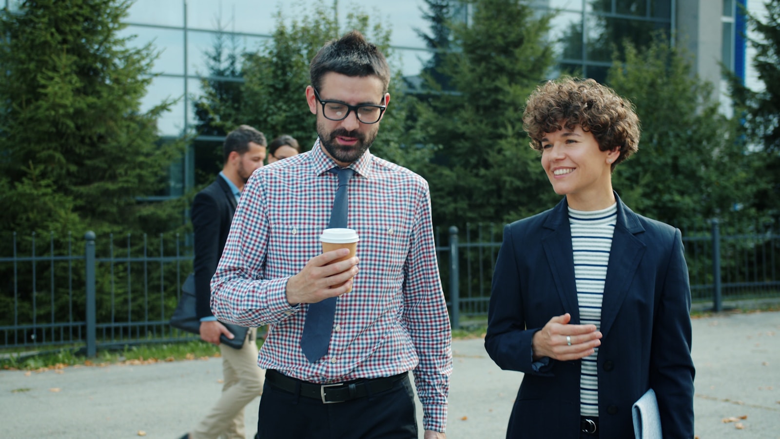 Two colleagues walking and talking outside office building