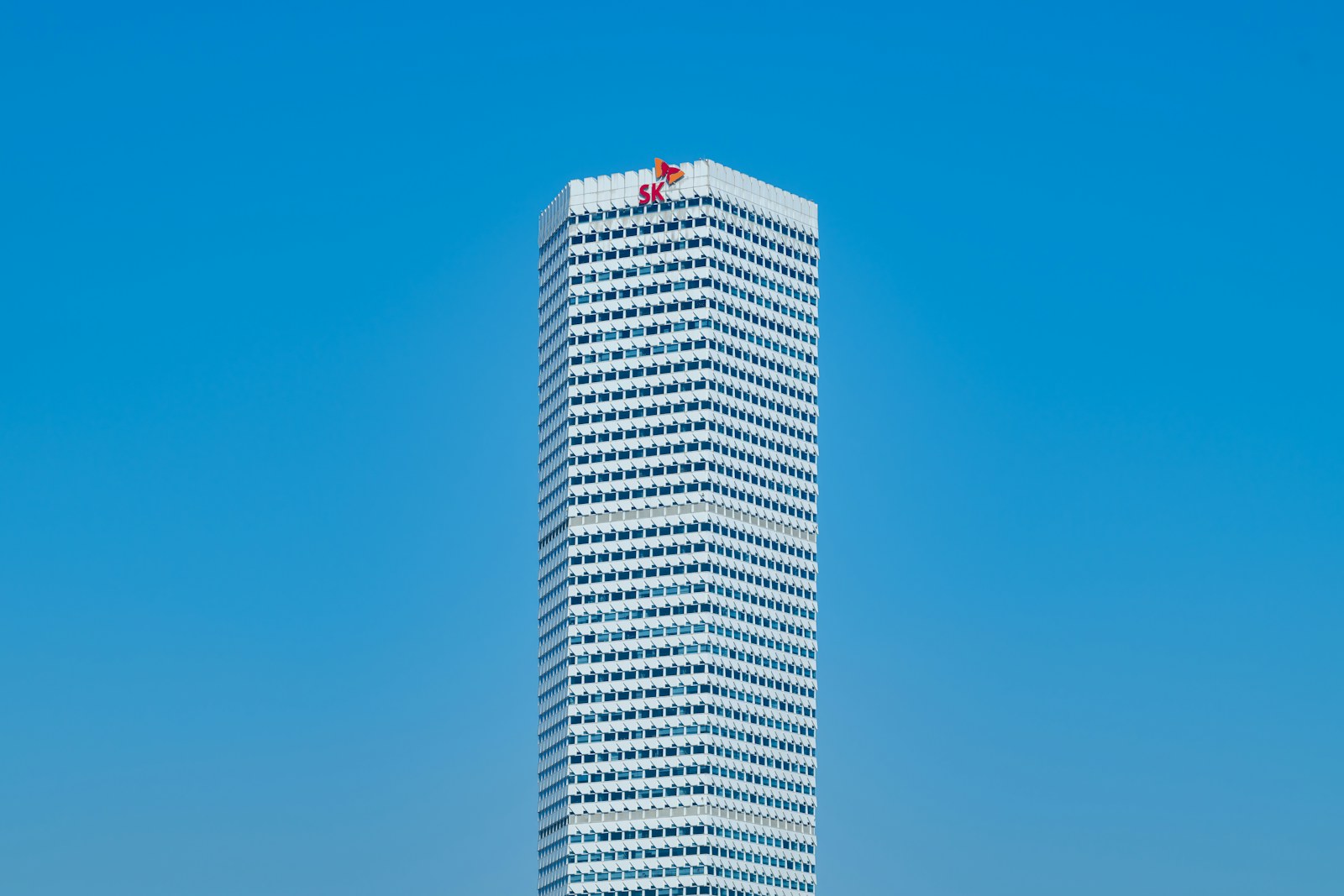 A tall white building sitting next to a body of water