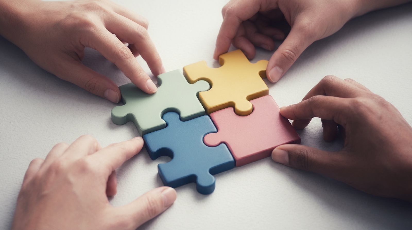 Hands connecting colorful puzzle pieces together