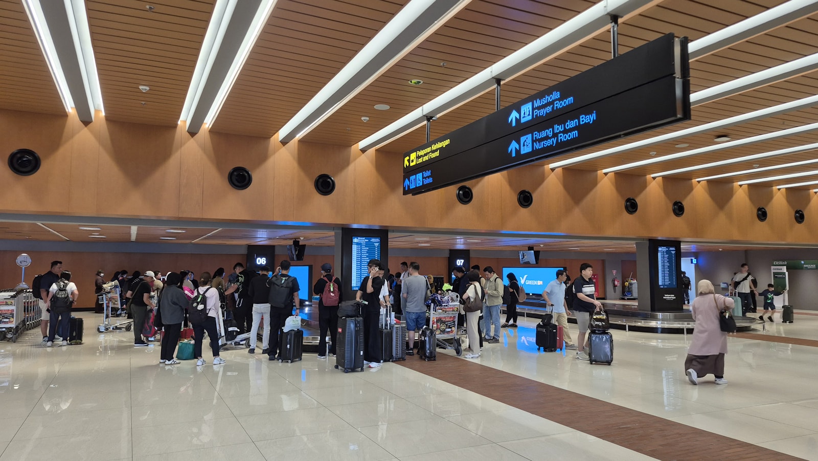 Travelers with luggage waiting in a modern airport terminal