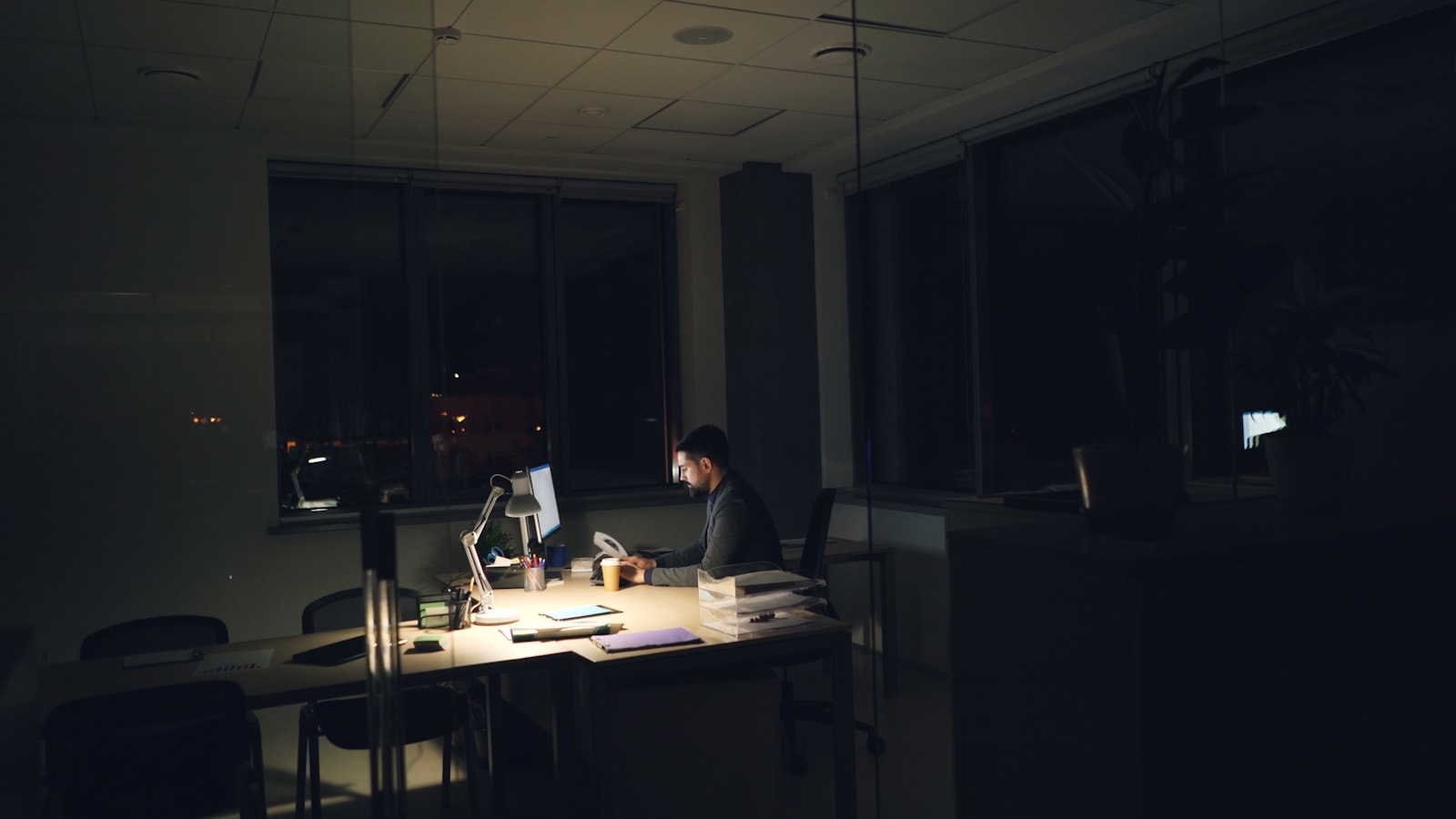 Man working late at a dimly lit office desk