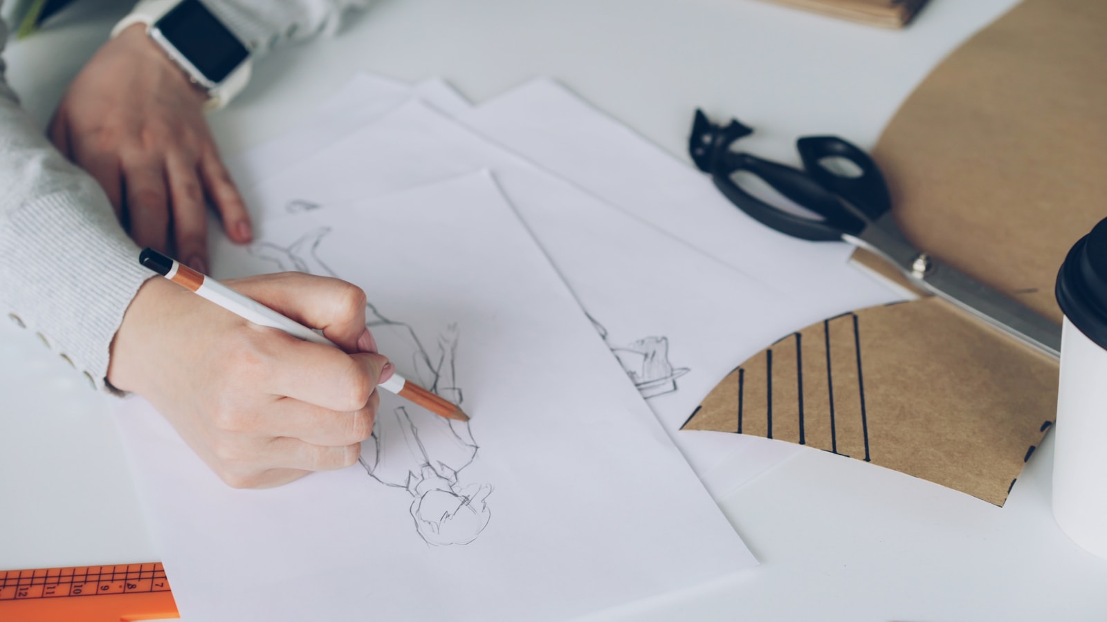 A person sketches a design on paper