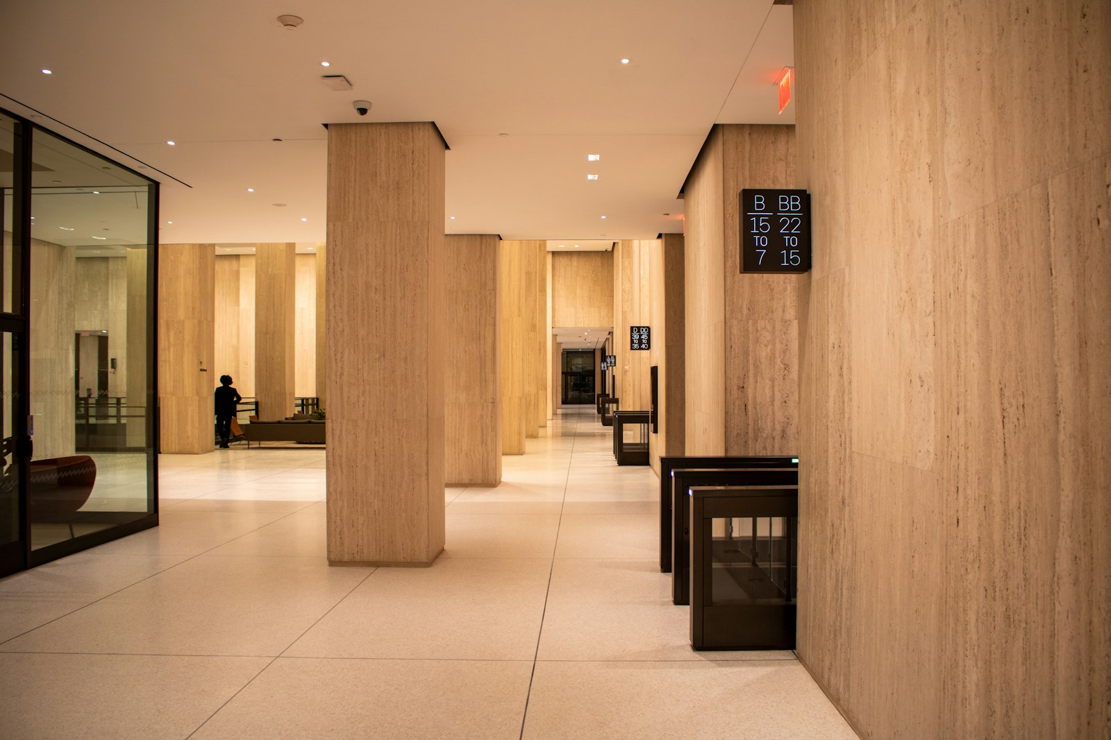 A modern lobby with pillars and a security gate