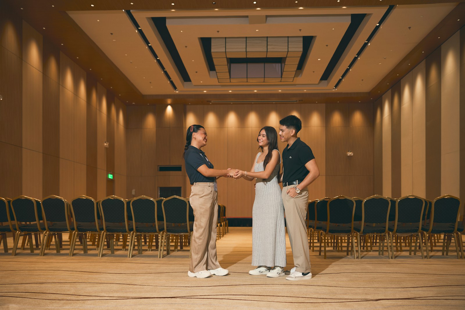 Three people standing in an empty conference room