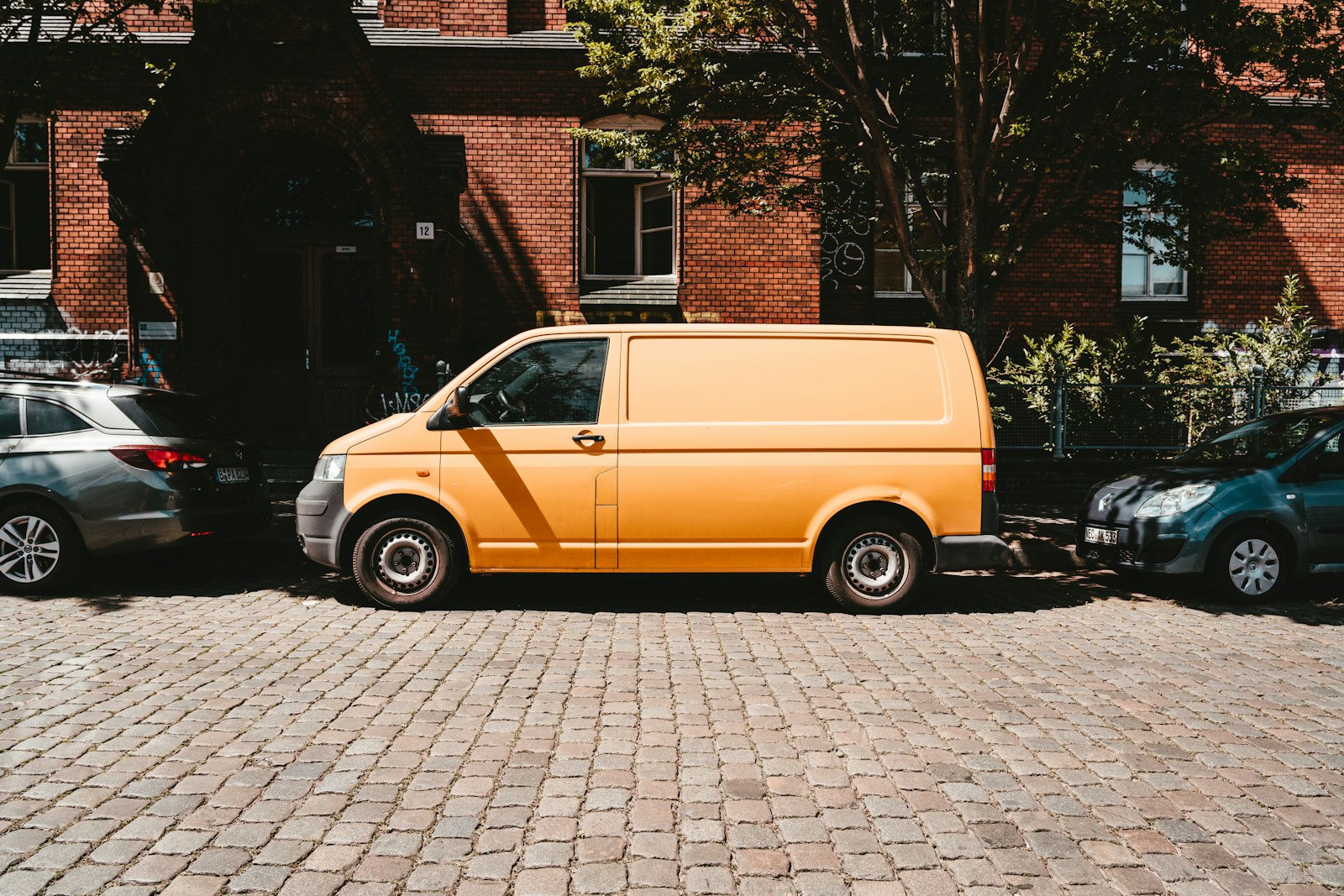 yellow van parked beside brown brick building