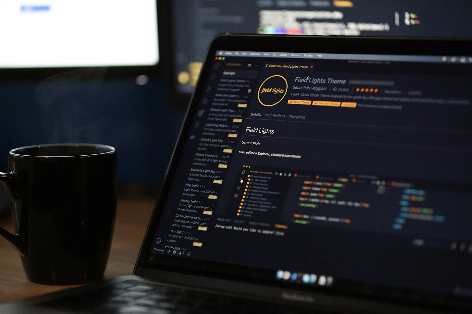 A laptop screen displaying code and a steaming mug on a desk