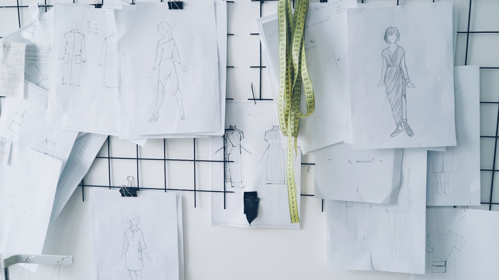 Fashion sketches pinned on a grid board