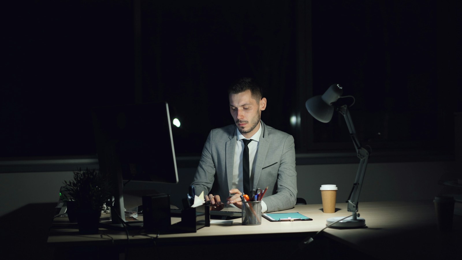 Man working late at his desk with coffee