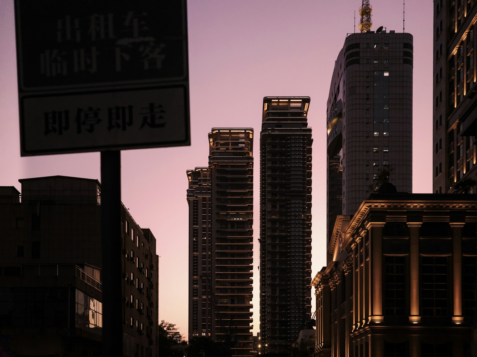 Skyscrapers silhouetted against a purple sunset sky