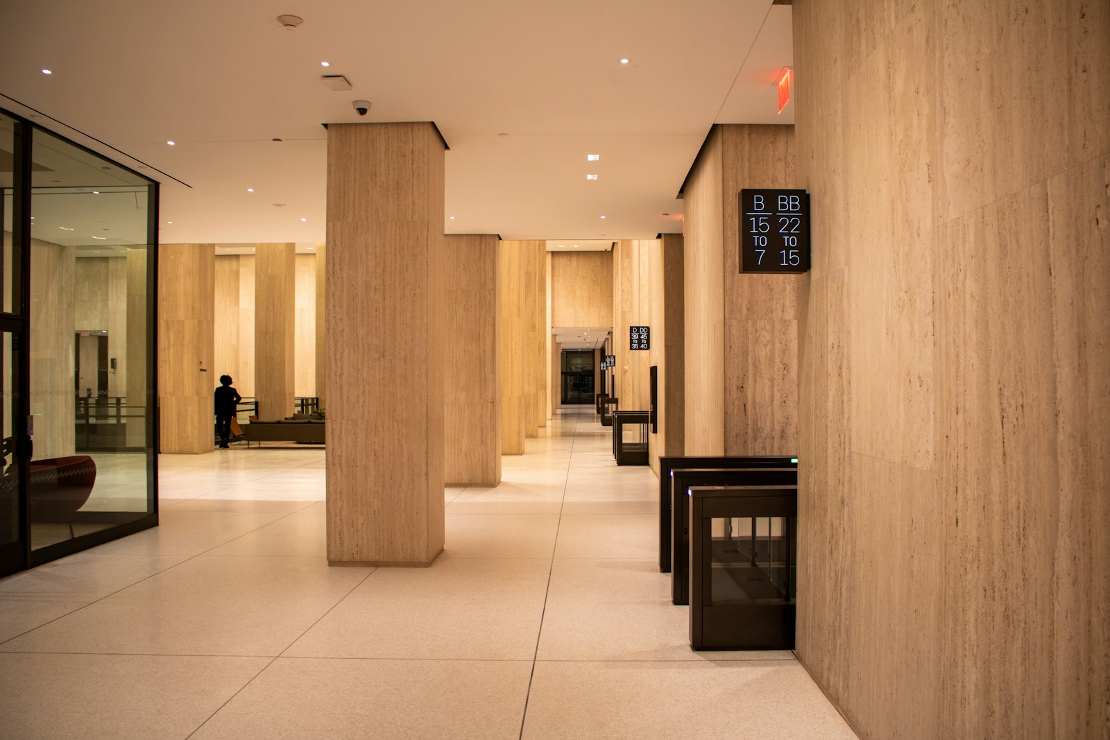 A modern lobby with pillars and a security gate