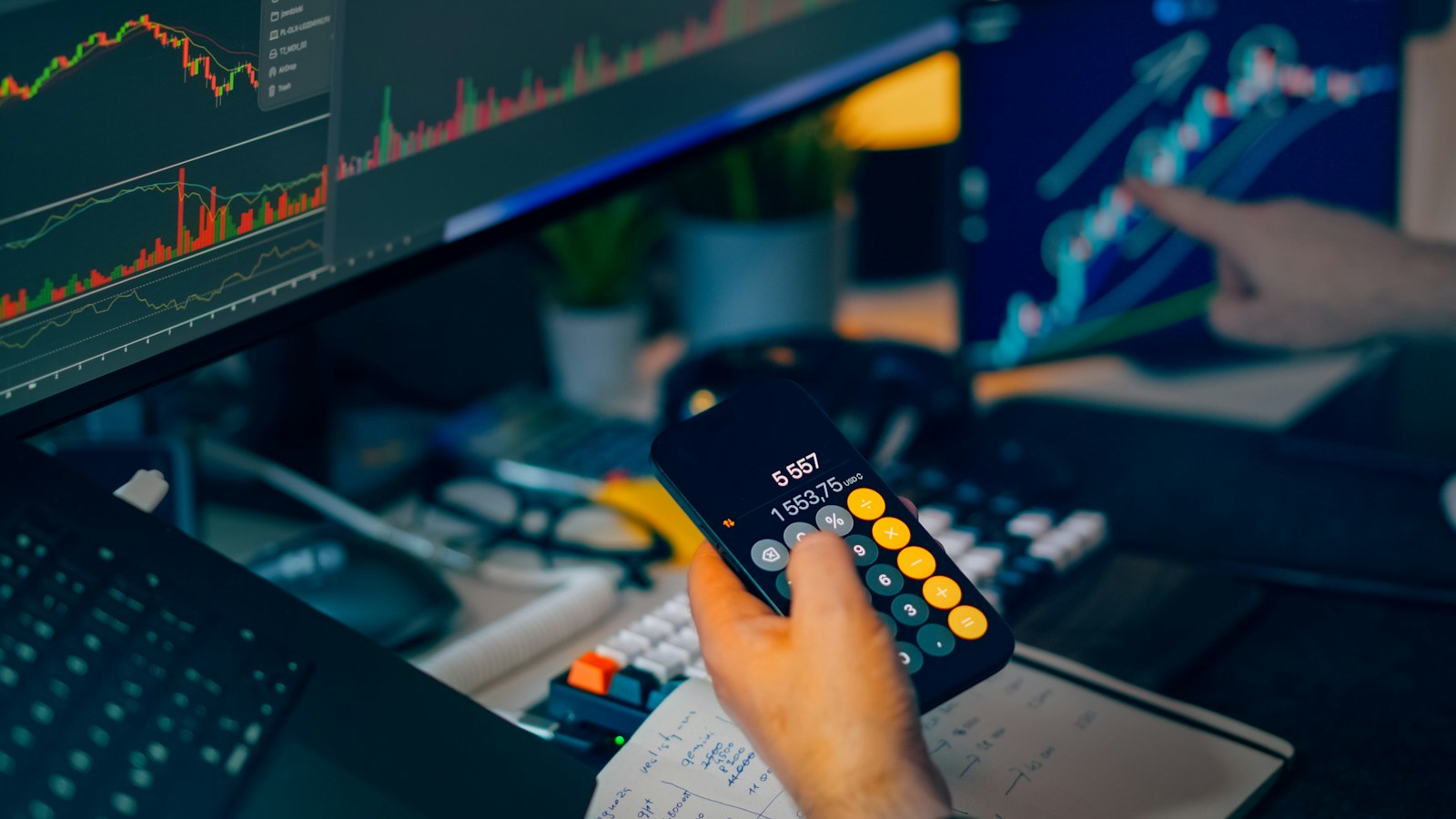 Trader analyzing stock market charts on computer screens with calculator