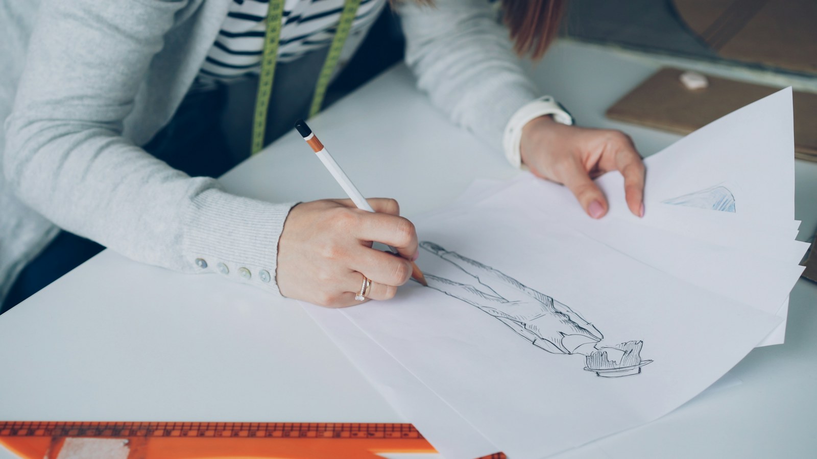 A fashion designer sketches a garment