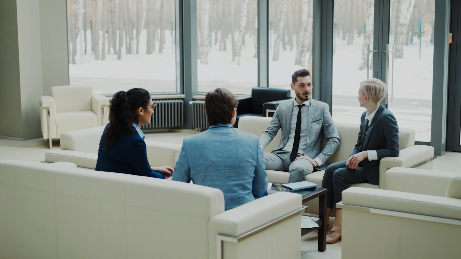 Four professionals in a modern office meeting space