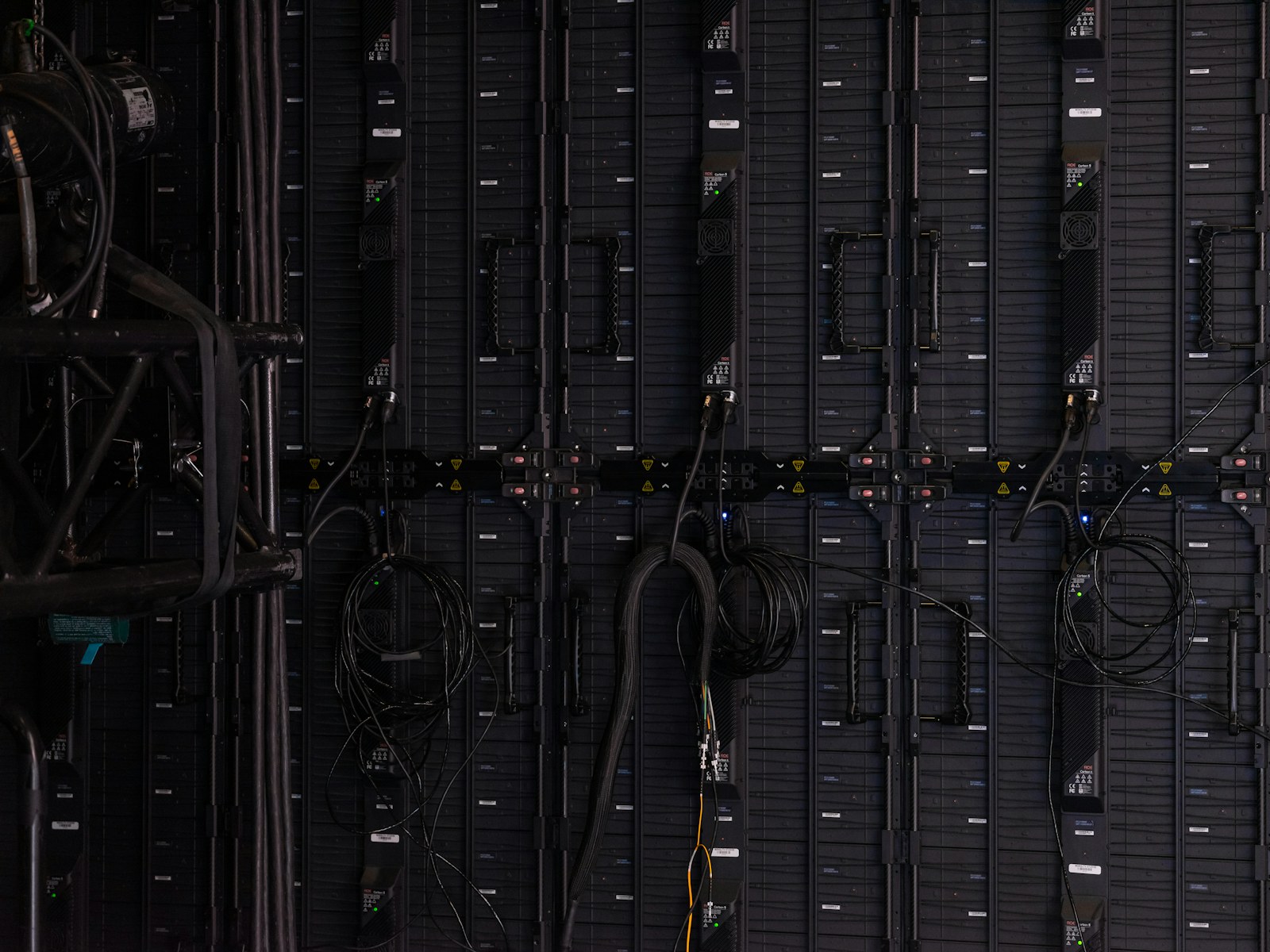 Black cables and wires connected to the back of modular LED display panels