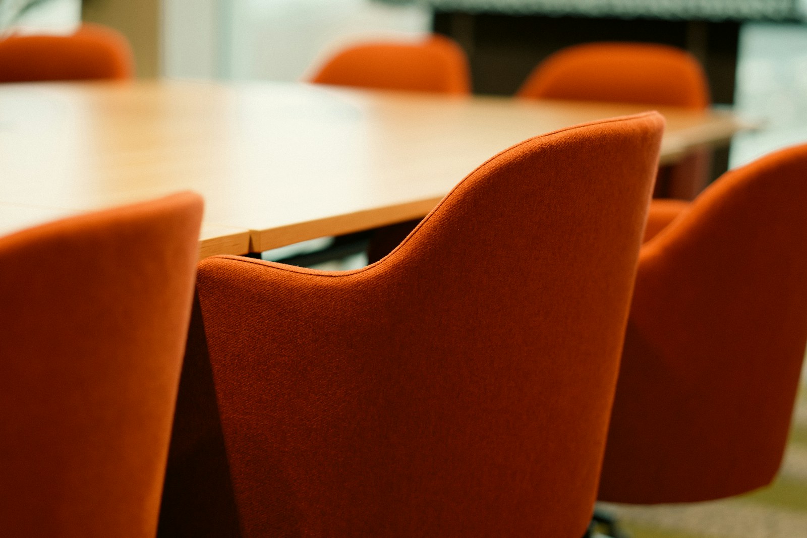 Orange chairs around a wooden conference table