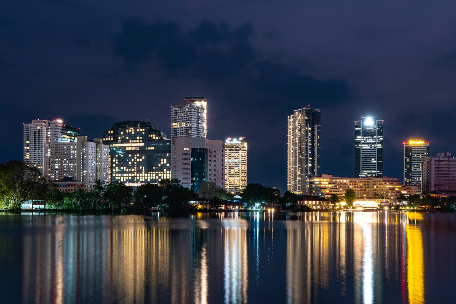 Illuminated cityscape at night reflecting on calm water
